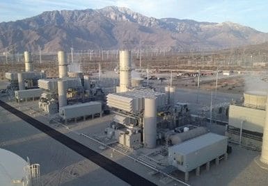 A large industrial area with mountains in the background.