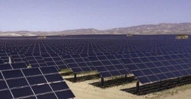 A large field of solar panels in the desert.