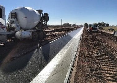 A cement pipe laying on top of the ground.