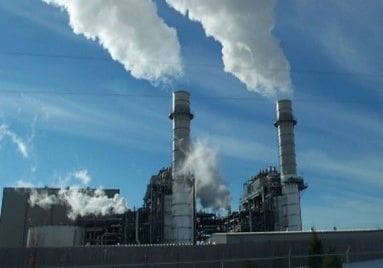 A factory with smoke coming out of the stacks.