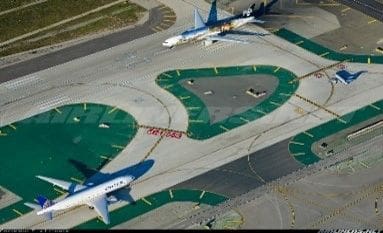 A view of an airport from above with planes on the runway.