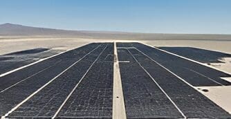 A large solar panel sitting on top of an open field.