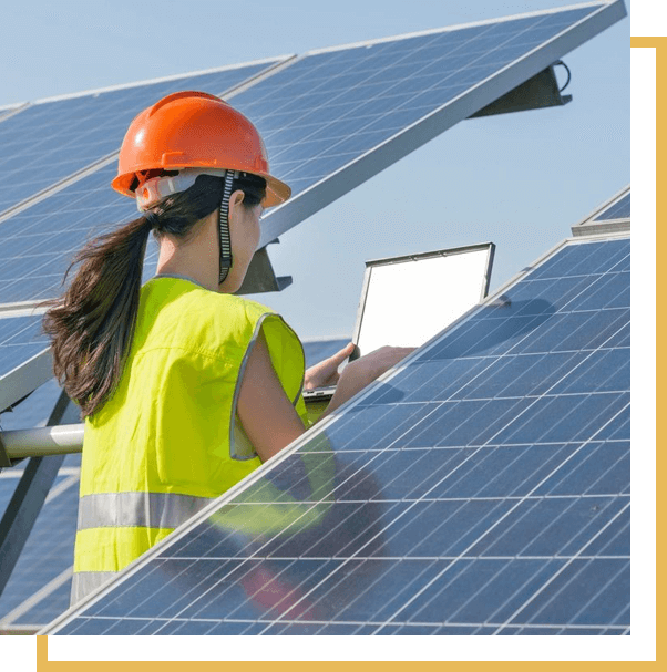 A woman in an orange helmet is working on solar panels.